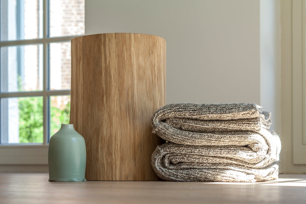 Hocker PAUL aus massiver Eiche mit gefalteten Decken und Vase